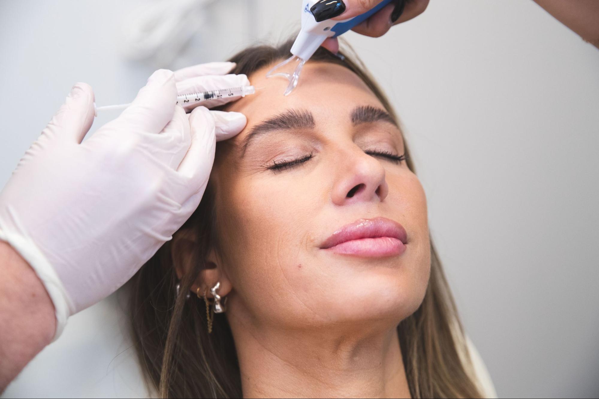 Woman receiving Botox treatment on forehead by a plastic surgeon in Washington, DC, highlighting aesthetic enhancements and pre-fall refresh options.